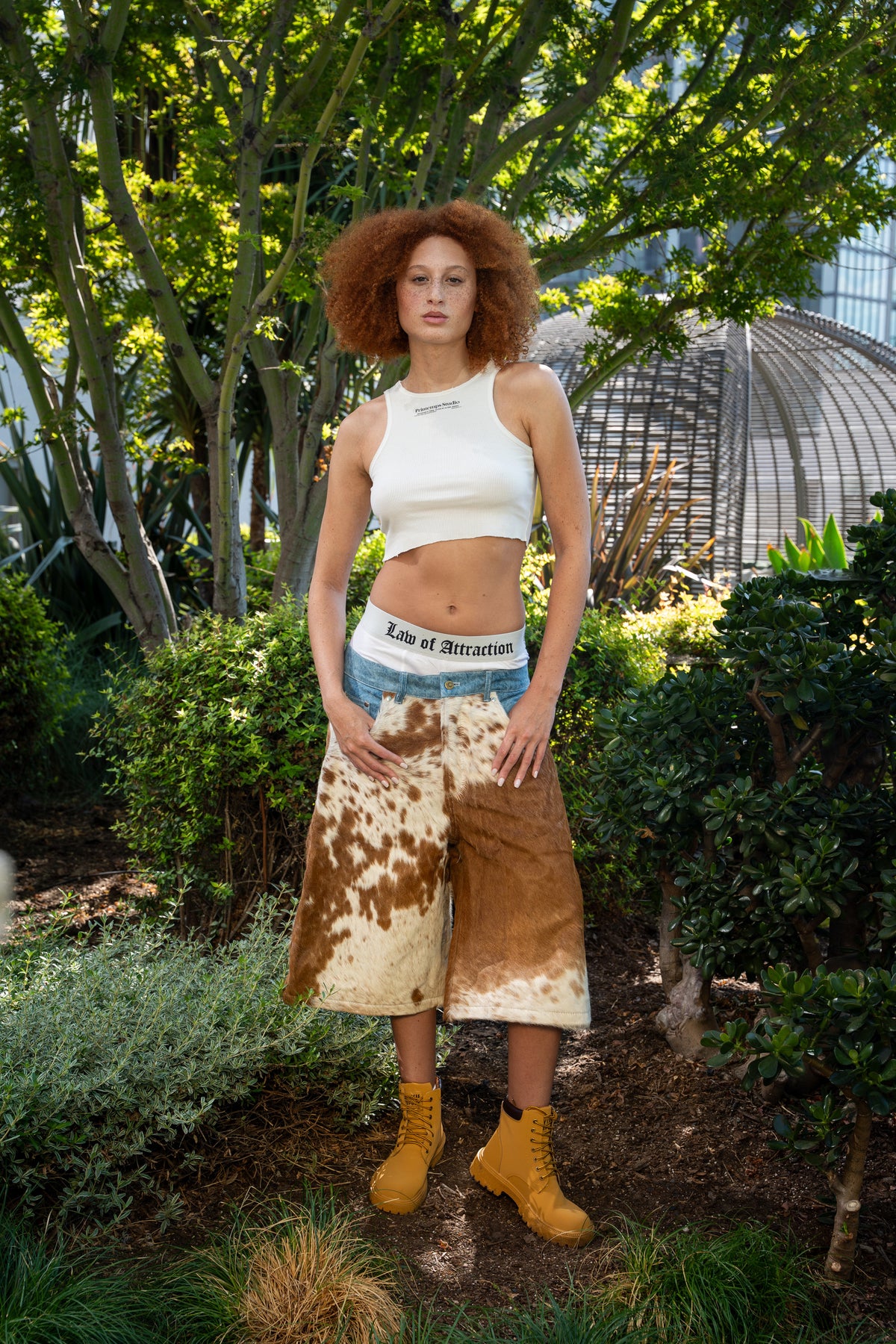 Brown and ivory cowhide denim shorts worn outdoors — full front silhouette