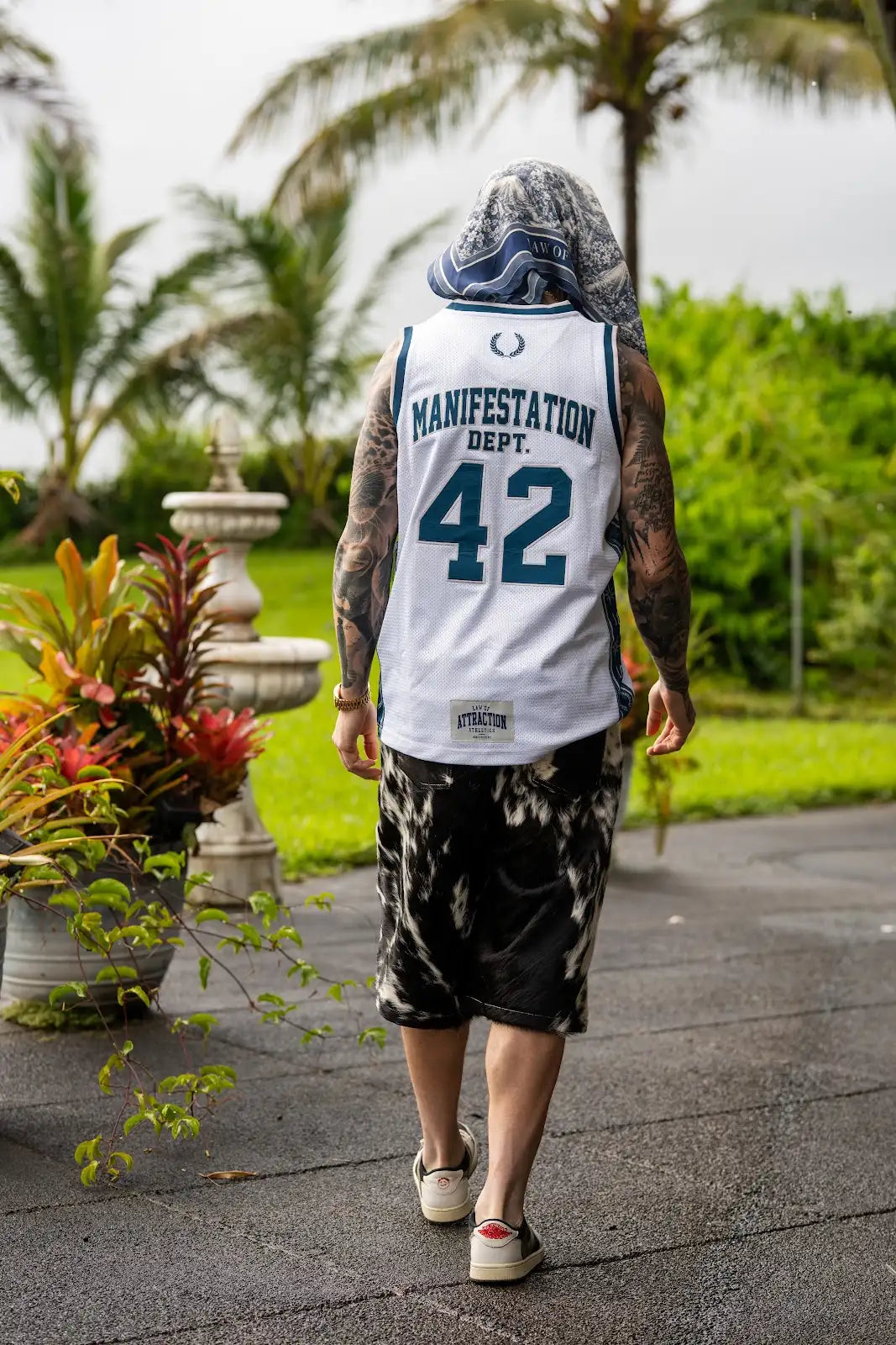 Back view of a white-and-blue Manifestation Dept. 42 basketball jersey with black-and-white cowhide shorts and a navy scarf.